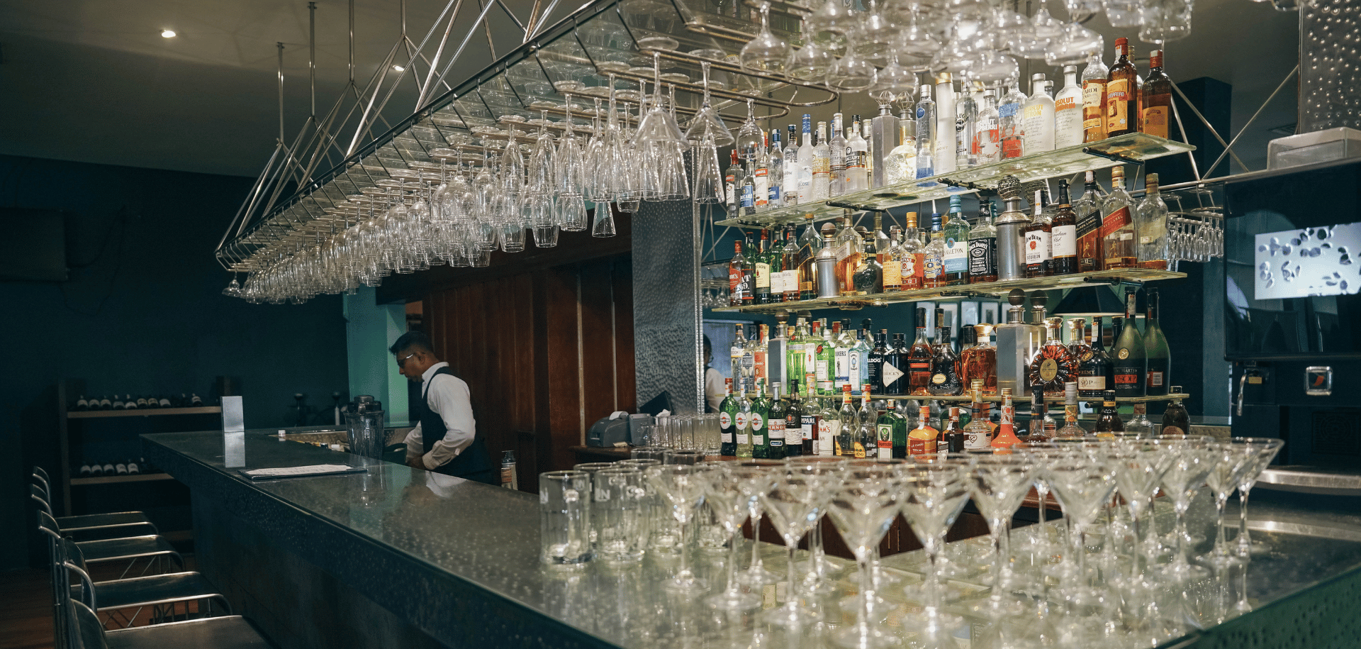 Bartender attending a cocktail bar with a premium liquor display